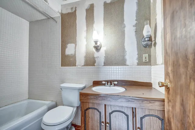 a bathroom with a granite countertop toilet a sink and a mirror