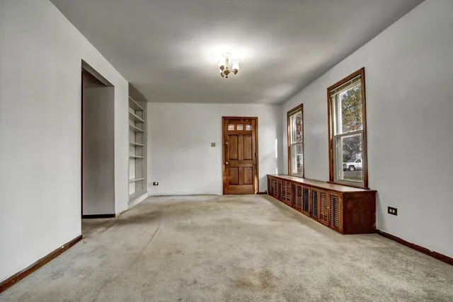 an empty room with windows and closet