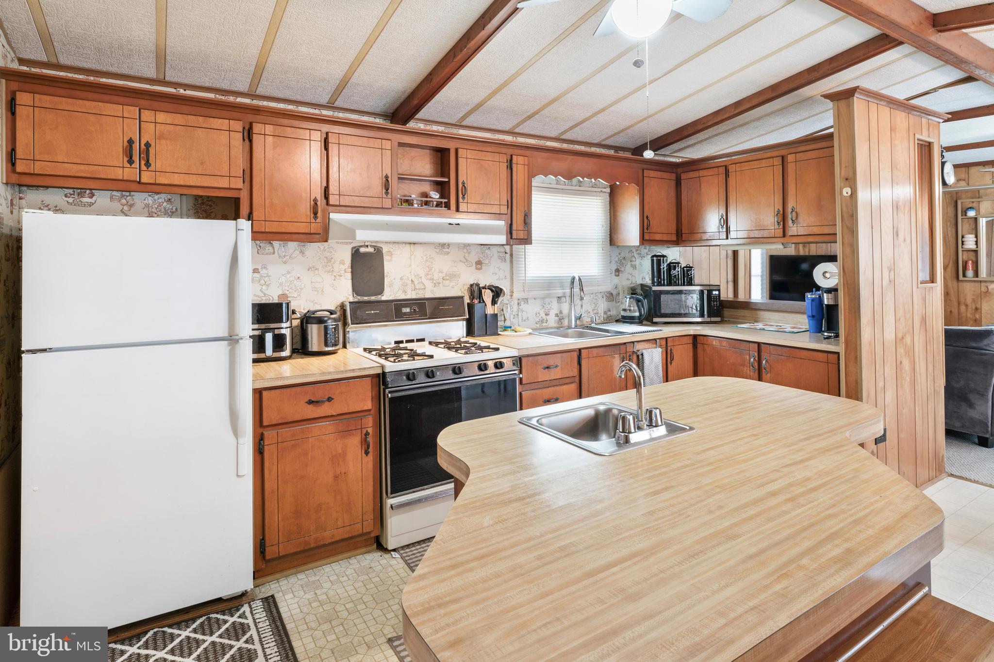 417 Captain Smith Lane Buena, NJ 08310 - Photo 17 of 31 a kitchen with stainless steel appliances granite countertop a refrigerator a sink dishwasher a stove with wooden cabinets and floor