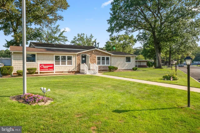 a front view of a house with a garden and trees