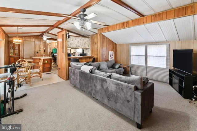 a living room with furniture a flat screen tv and a table