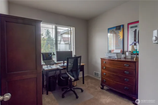 a view of a workspace with furniture and a window