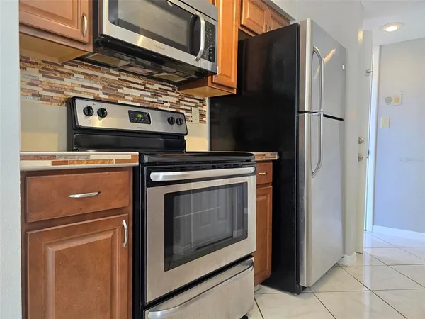 a kitchen with stainless steel appliances granite countertop a refrigerator and a stove