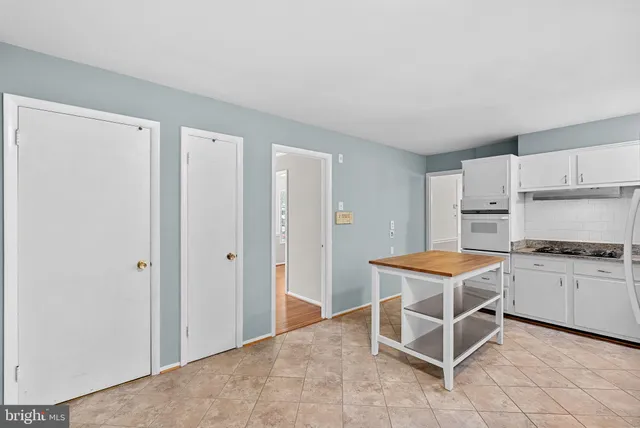 a kitchen with stainless steel appliances a stove a refrigerator and white cabinets