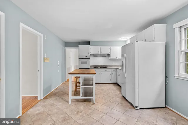a kitchen with white cabinets and white appliances