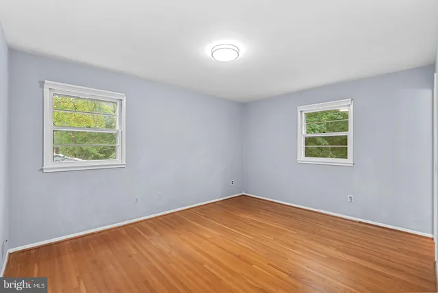 a view of a room with wooden floor and windows