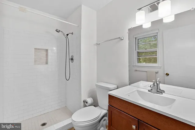 a bathroom with a sink toilet a mirror and shower