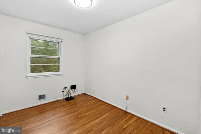a room with a wooden floor and a window