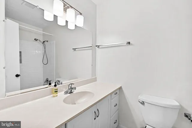 a bathroom with a sink and mirror with toilet