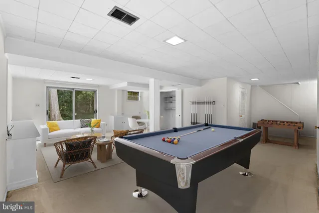 a room with furniture pool table and windows