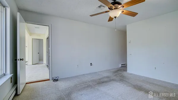 a view of a room with a ceiling fan and window