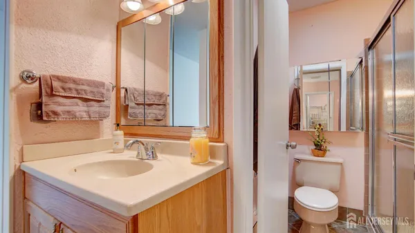 a bathroom with a sink toilet and shower a mirror