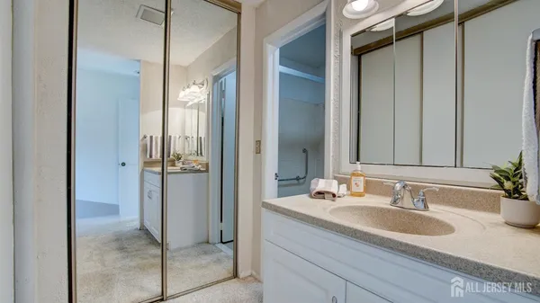 a bathroom with a granite countertop sink and a mirror
