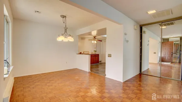 a view of a hallway with wooden floor and a chandelier