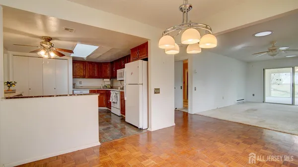 a view of a kitchen with refrigerator and wooden floor