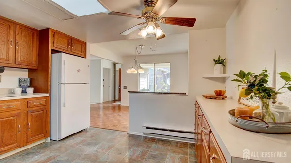 a kitchen with stainless steel appliances granite countertop a refrigerator a sink a stove and a dining table