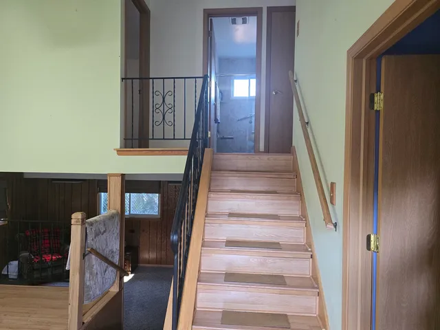 a view of staircase with lots of frames on wall and a window