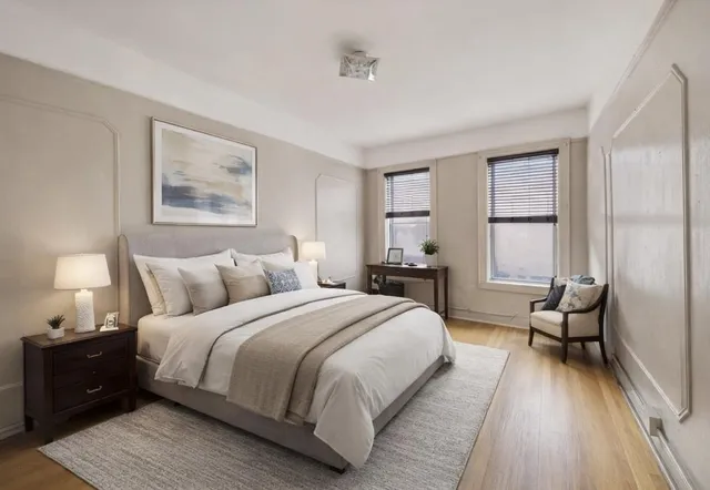 a large bedroom with a bed and wooden floor