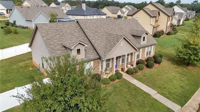 an aerial view of residential houses with outdoor space and trees