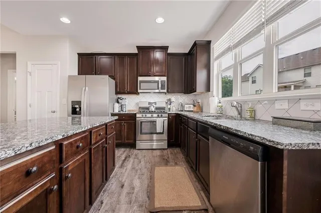 a kitchen with granite countertop stainless steel appliances and wooden cabinets