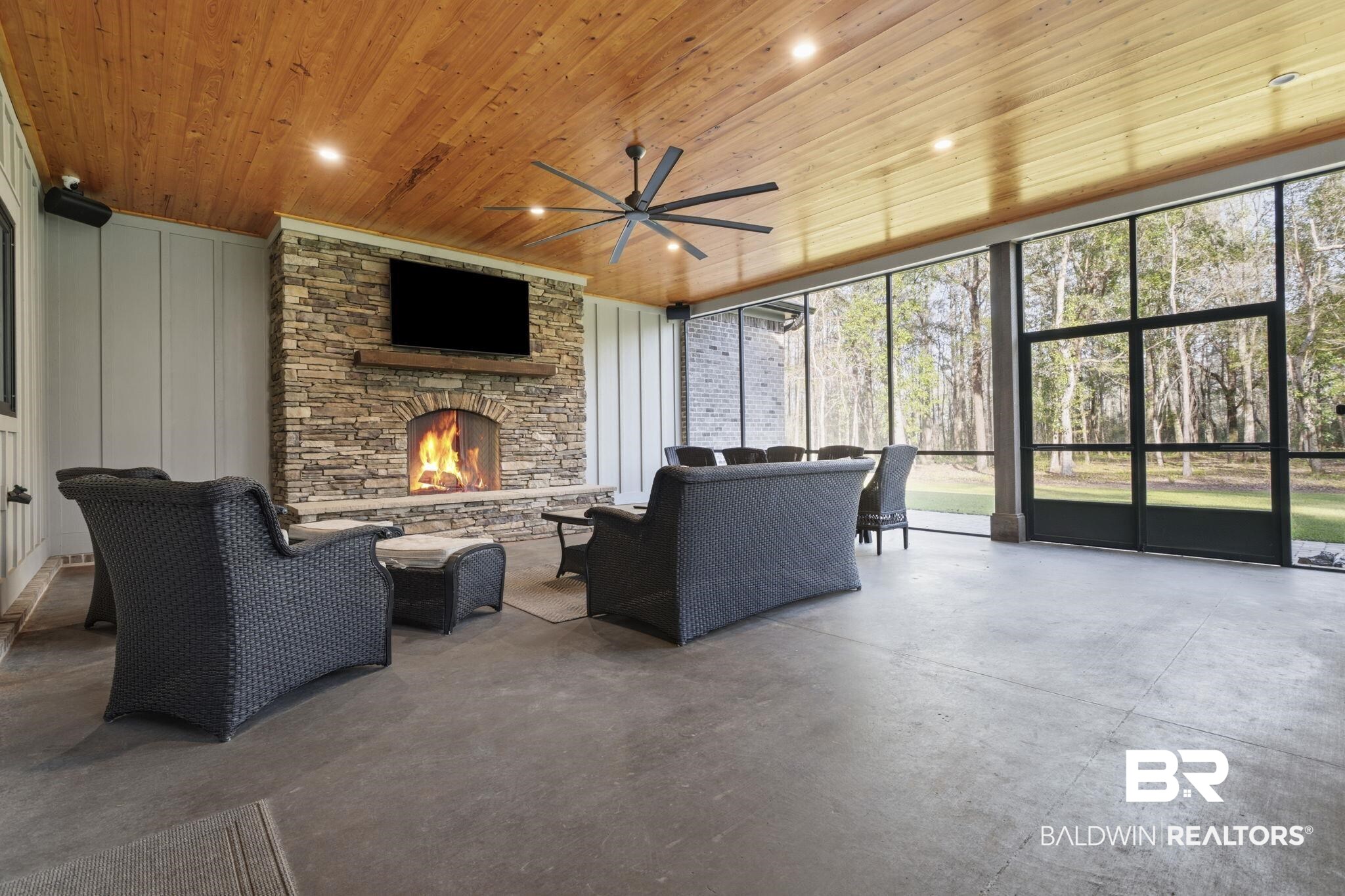 9501 Ben Hamilton Road Theodore, AL 36582 - Photo 61 of 69 Living area featuring concrete flooring, a stone fireplace, a ceiling fan, wood ceiling, and expansive windows