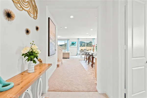 a kitchen with stainless steel appliances granite countertop a stove top oven a sink a refrigerator a dining table and chairs with wooden floor