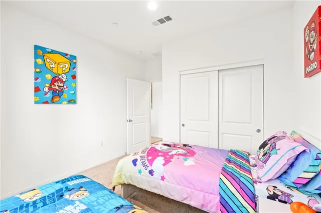 a bedroom with a bed and painting on the wall