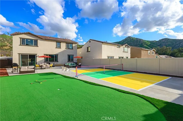 a view of a tennis court with a table and chairs