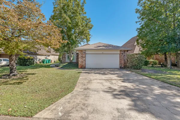 a front view of a house with a yard and trees