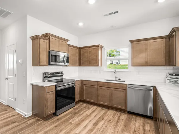 a kitchen with stainless steel appliances granite countertop a sink stove and refrigerator