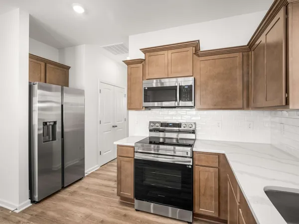 a kitchen with stainless steel appliances a stove a microwave and a sink