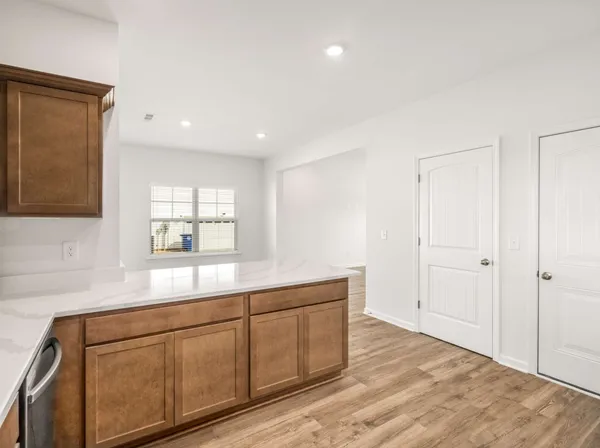 a hallway with white cabinets and wooden floor