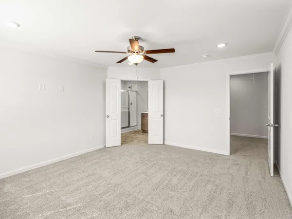 an empty room with closet and a ceiling fan
