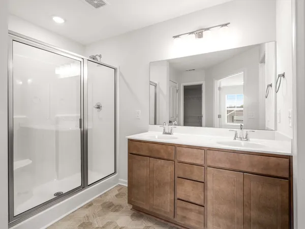 a bathroom with a double vanity sink mirror and shower