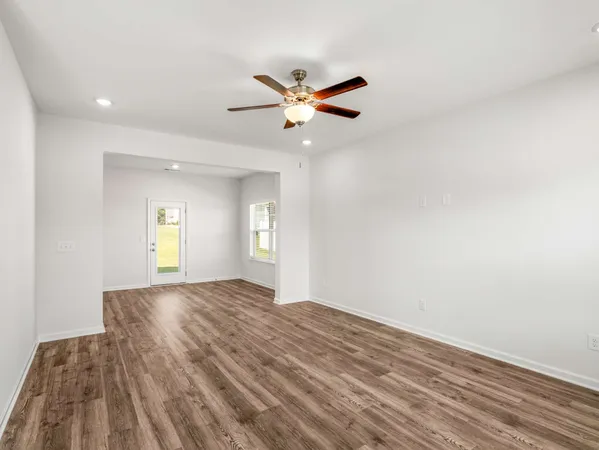 a view of empty room with window and ceiling fan
