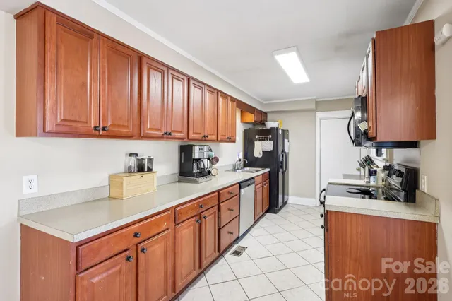 a kitchen with stainless steel appliances a sink dishwasher stove refrigerator and cabinets