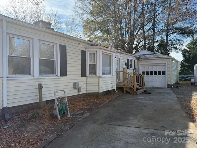 a view of a house with a yard and wooden fence