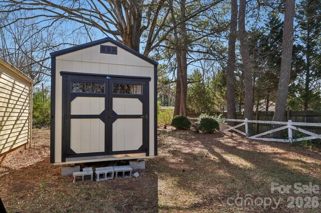a view of backyard with a table and chairs and a large tree