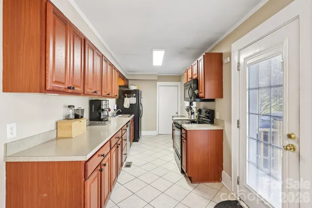 a kitchen with a refrigerator a stove top oven cabinetry a sink and a window