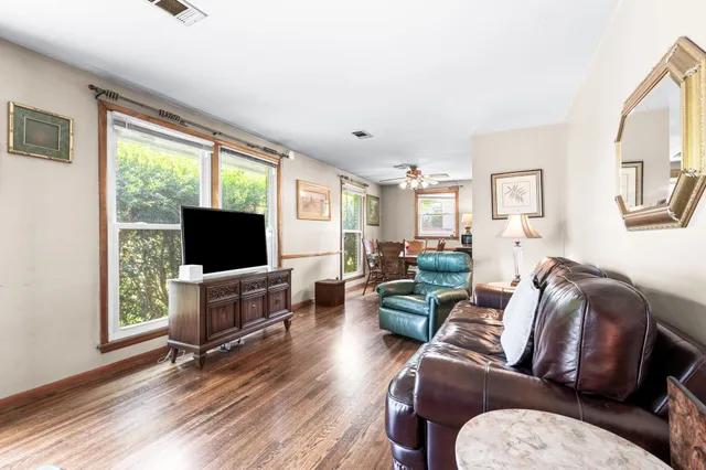 a living room with furniture a flat screen tv and a large window