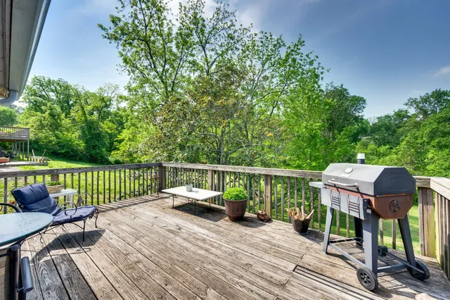 a balcony with wooden floor table and chairs
