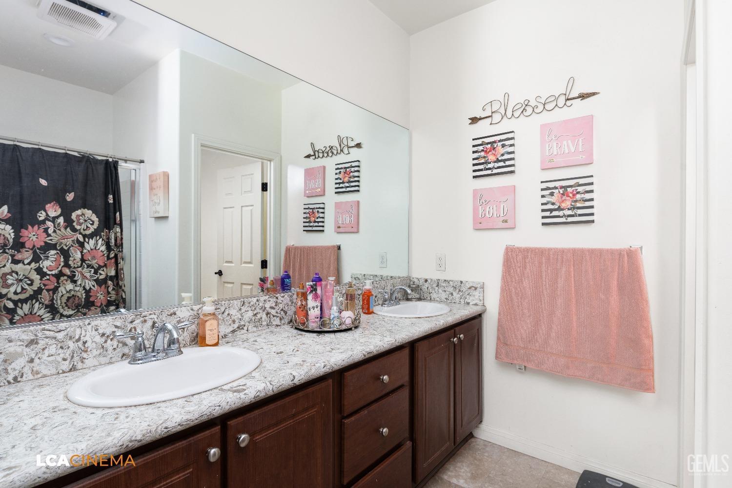 Undisclosed Address Bakersfield, CA 93304 - Photo 16 of 19 a bathroom with a granite countertop sink and a mirror