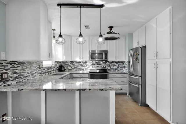 a kitchen with stainless steel appliances granite countertop a refrigerator a oven a sink a stove and a refrigerator