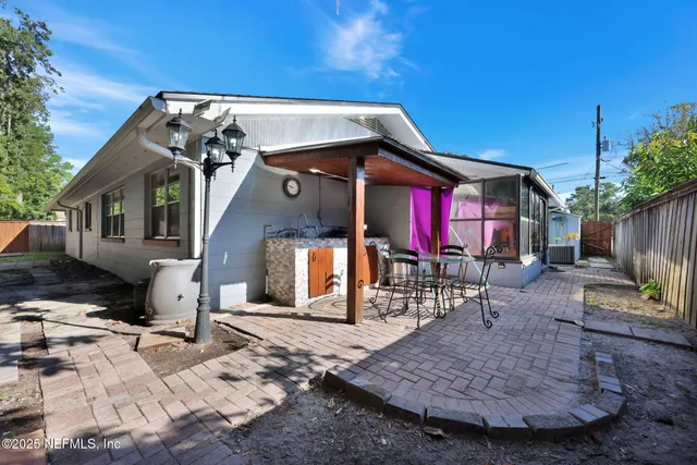 a backyard of a house with lawn chairs and wooden fence