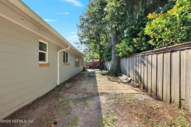 a view of a backyard with wooden fence and floor
