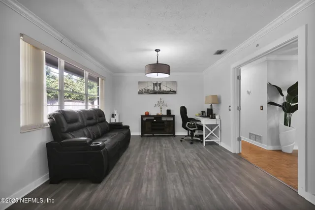 a living room with furniture and a wooden floor