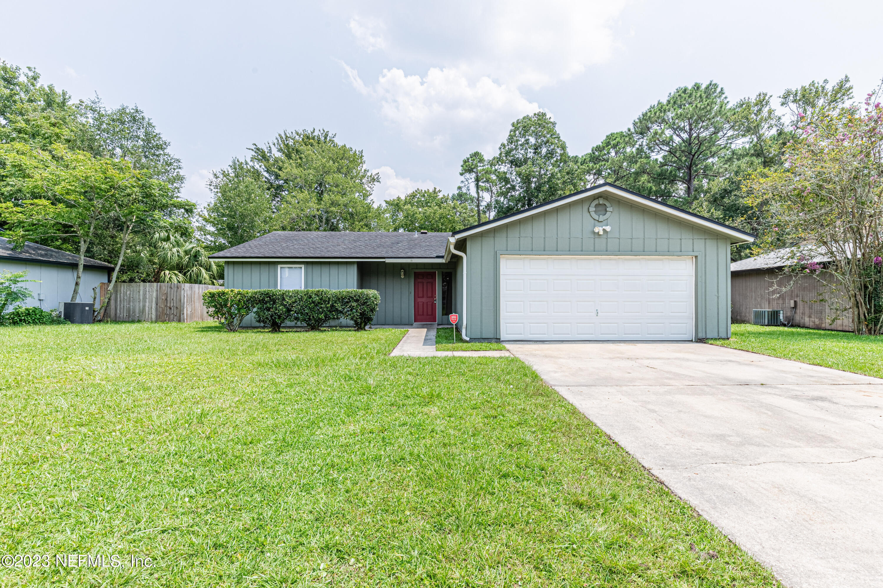 a front view of a house with a yard and trees