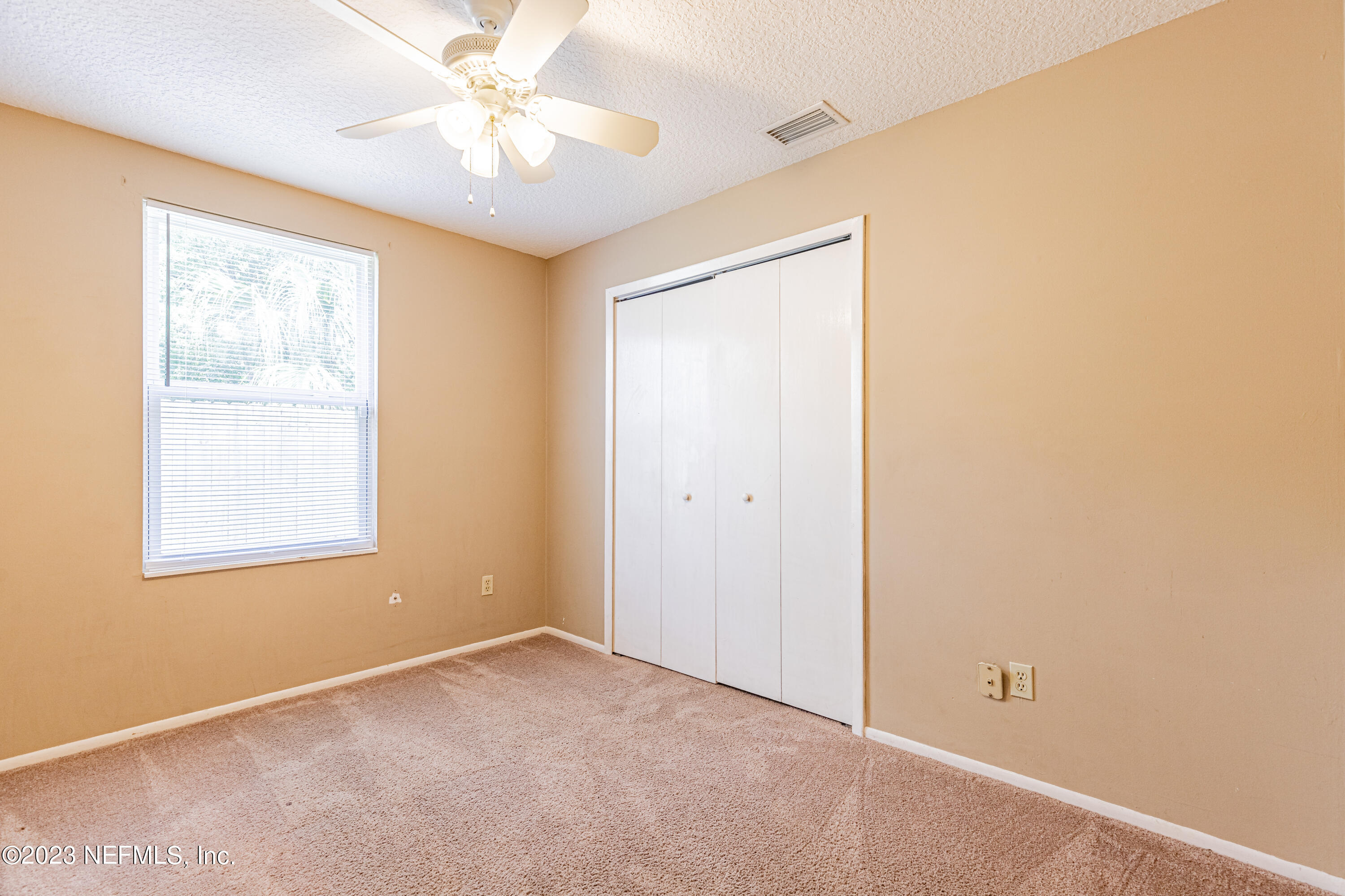 2833 Homestead Road Orange Park, FL 32065 - Photo 18 of 28 an empty room with a window and a fan