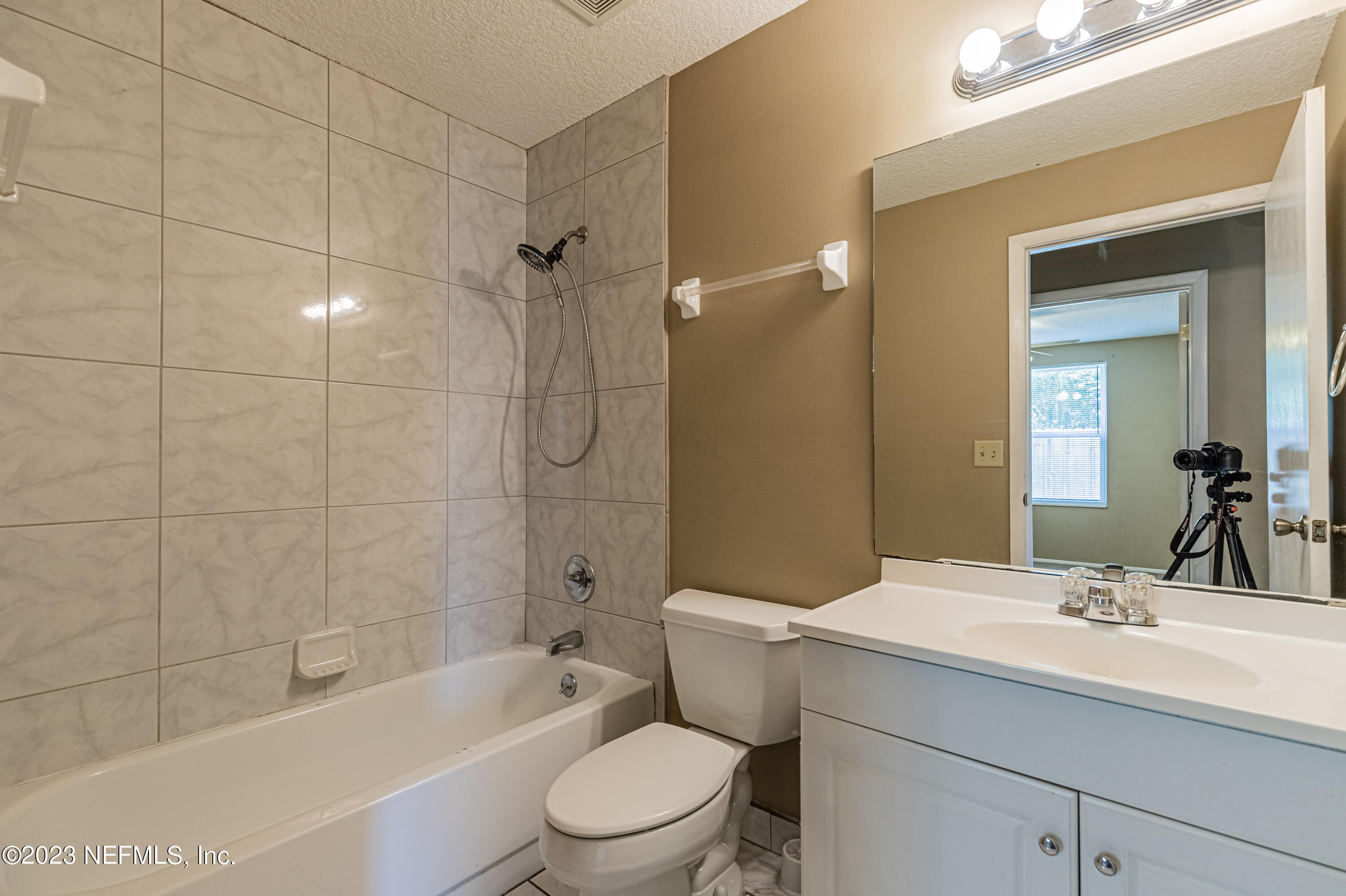2833 Homestead Road Orange Park, FL 32065 - Photo 20 of 28 a bathroom with a sink a toilet a mirror a bathtub and shower