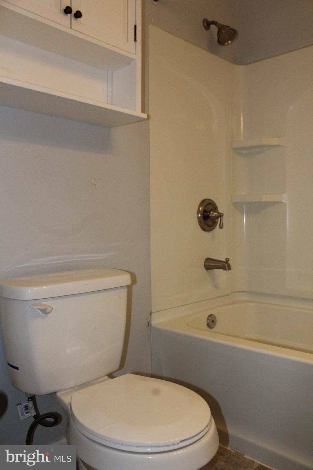 4529 Devonshire Road Harrisburg, PA 17109 - Photo 14 of 22 a white toilet sitting next to a bath tub